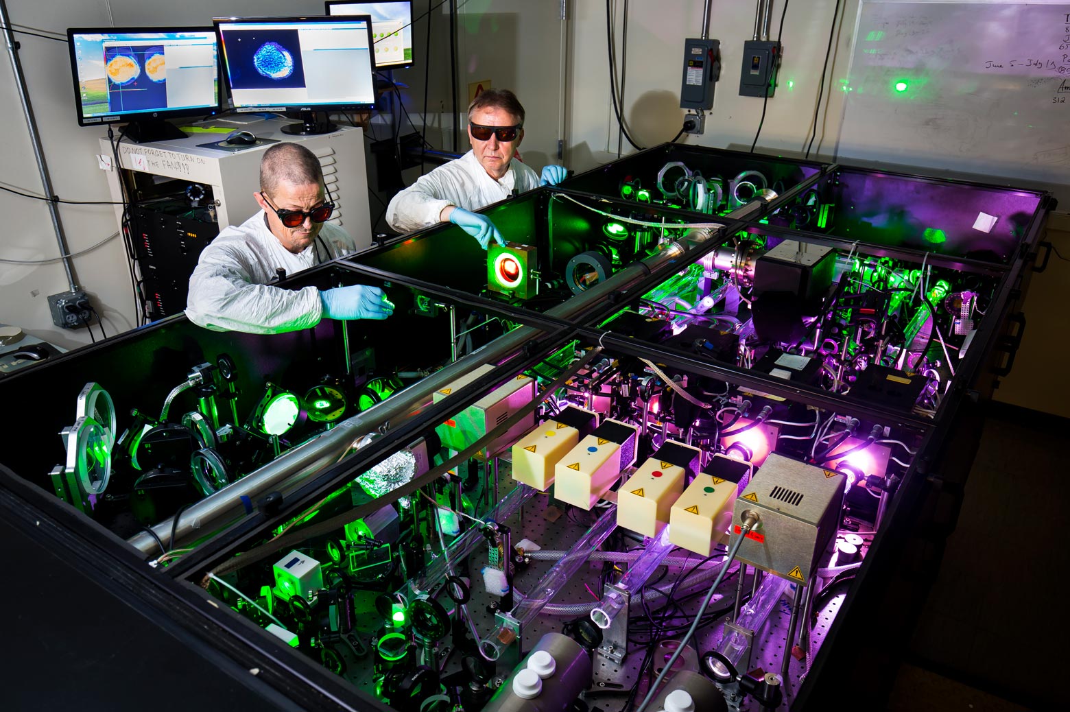Two scientists stand next to the HERCULES laser