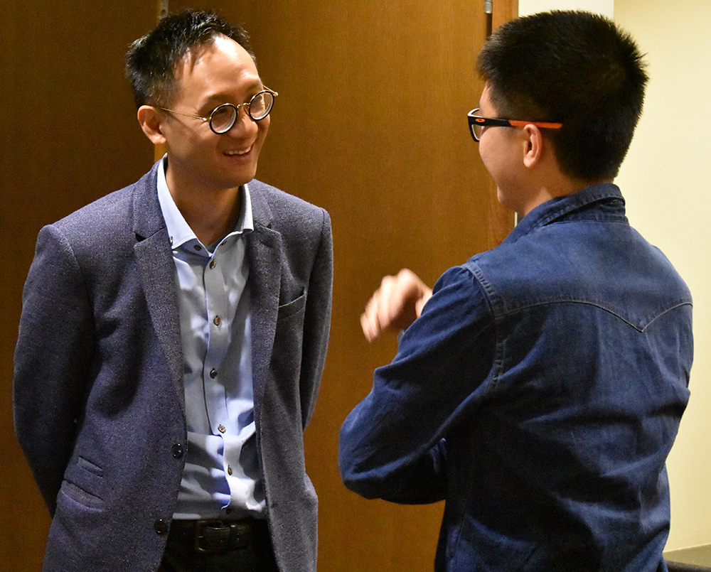 Tong chats with a student after his presentation.