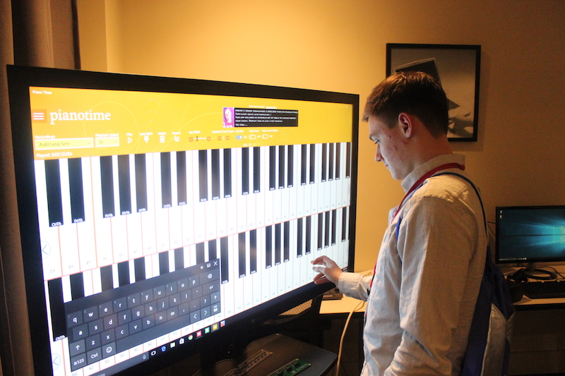 Student tries out the touch screen with a piano program on it