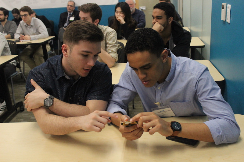 Two students examining a demo tech piece