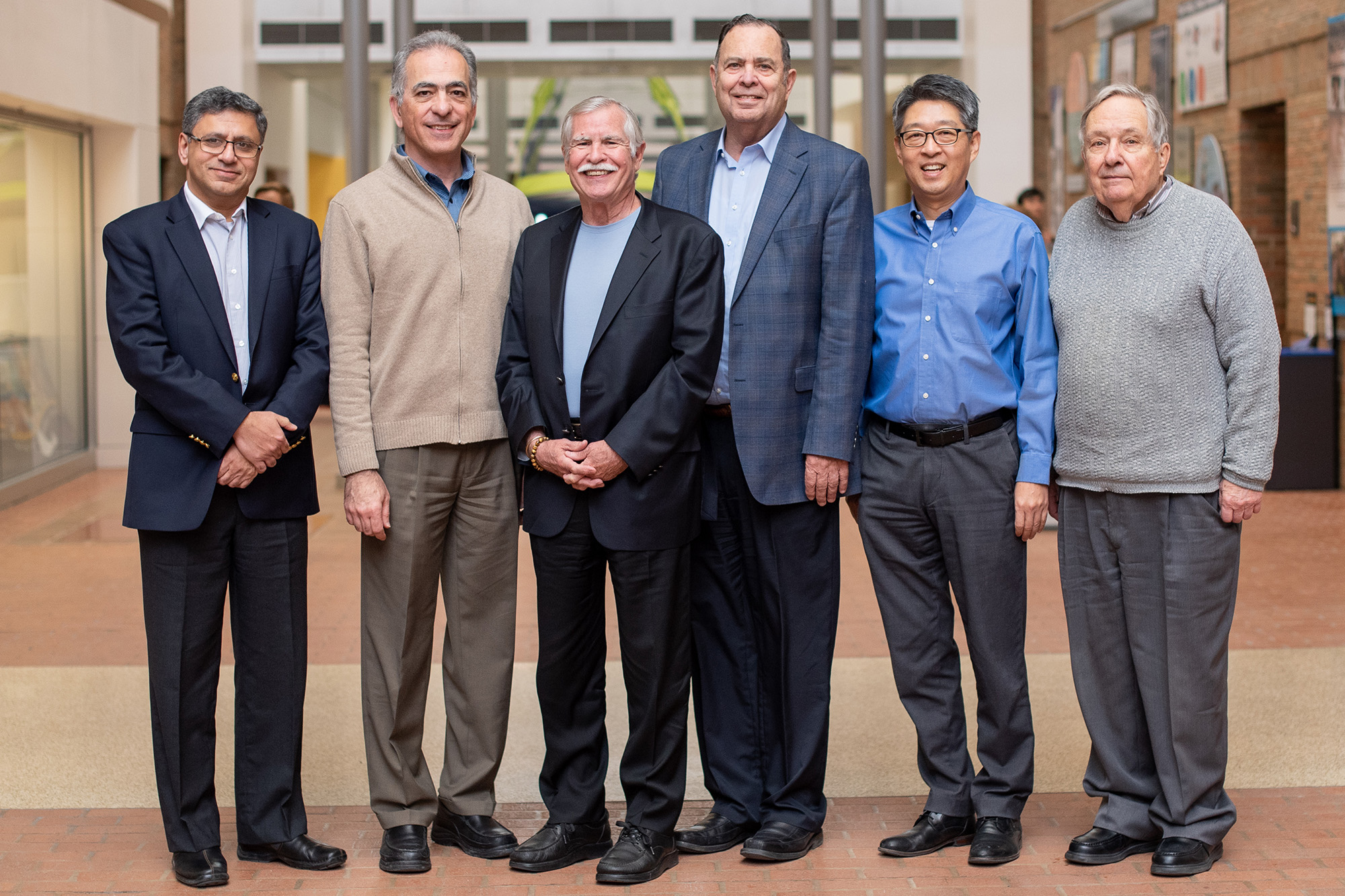 Dr. Kurt Petersen stands with a group of current and former faculty