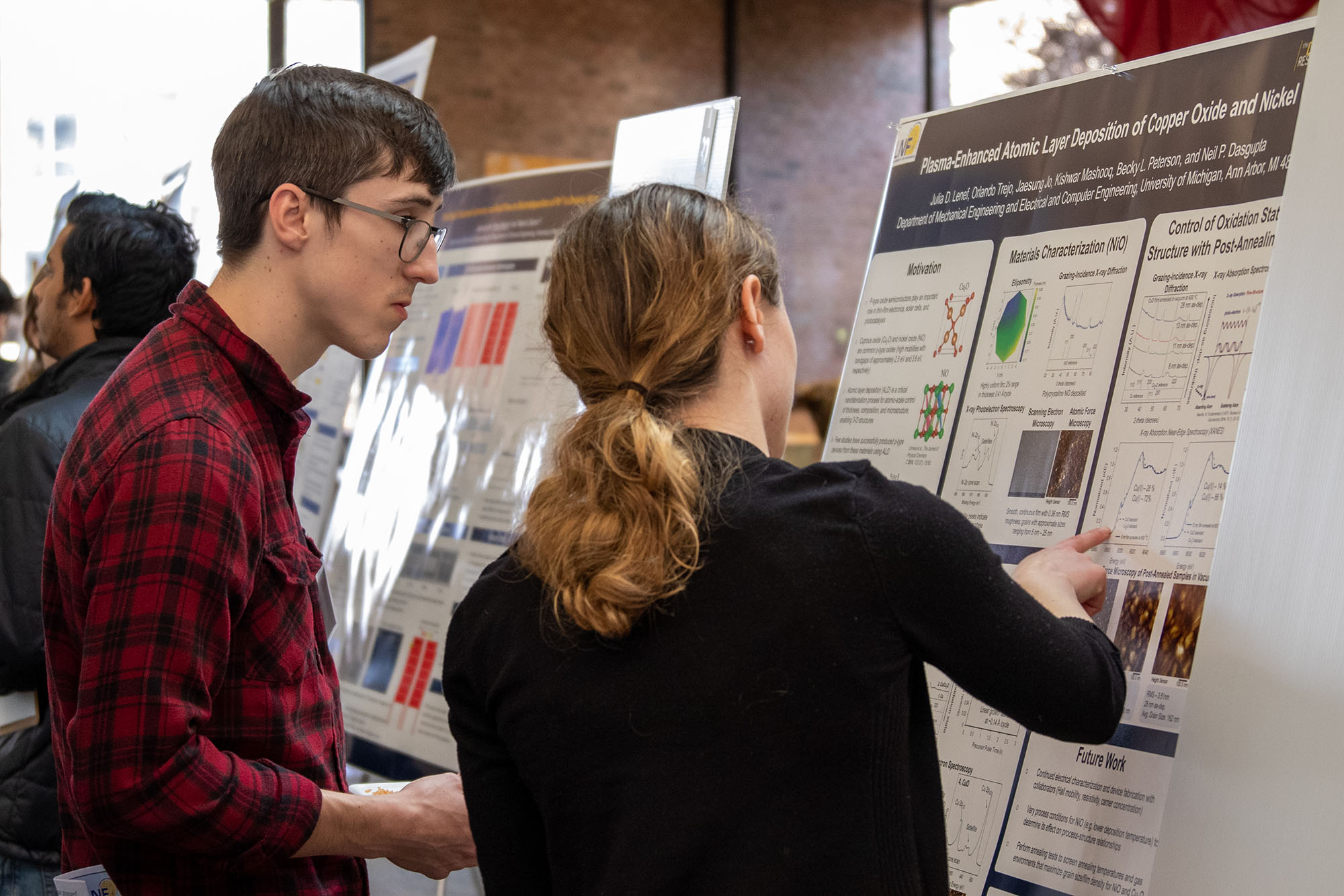Two students examine a poster during the symposium