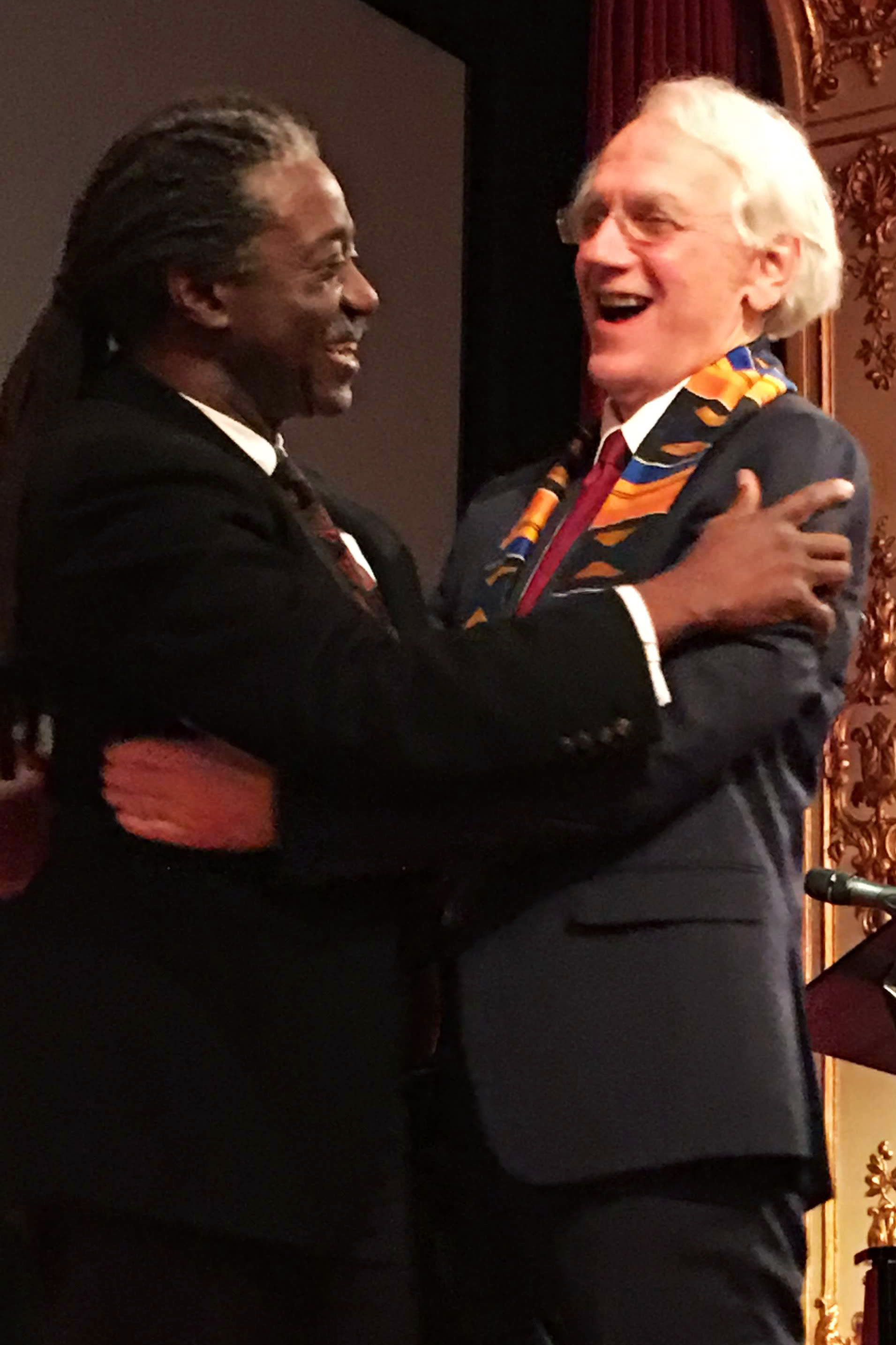 Herbert Winful and Gérard Mourou hug at at party for the 2018 Nobel Ceremony