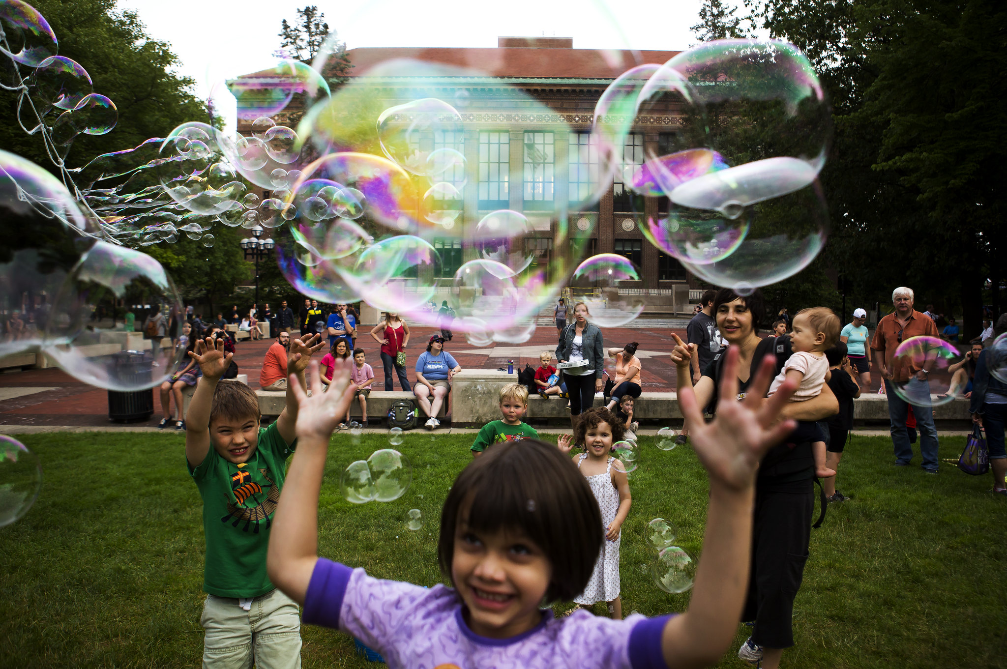 Kids play with bubbles outside of the Hatcher Graduate Library