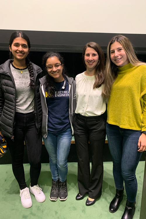 3 women students with Prof. Katie Bouman at a lecture at Rackham