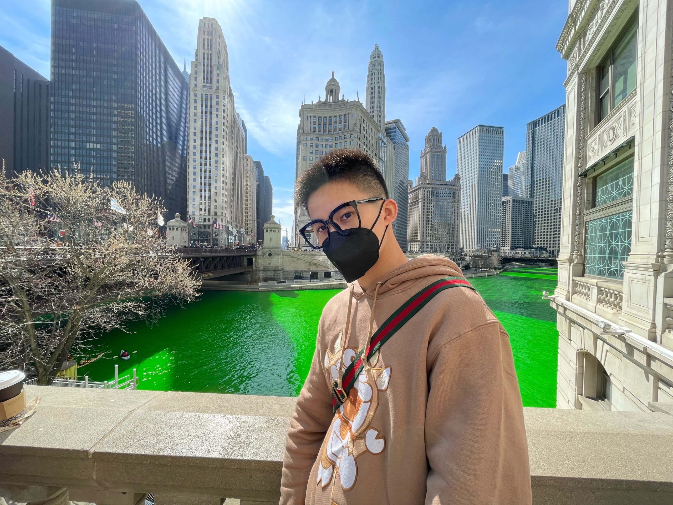 Kyle Luo on bridge in Chicago overlooking the green-colored river