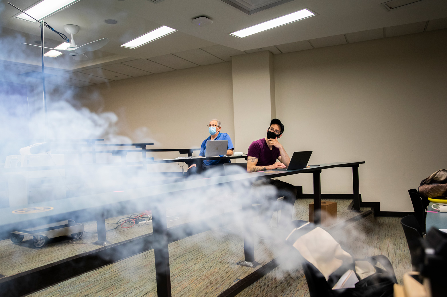 Jesse Capecelatro and Andre Boehman observe a smoke machine as they study how particles move through a classroom.