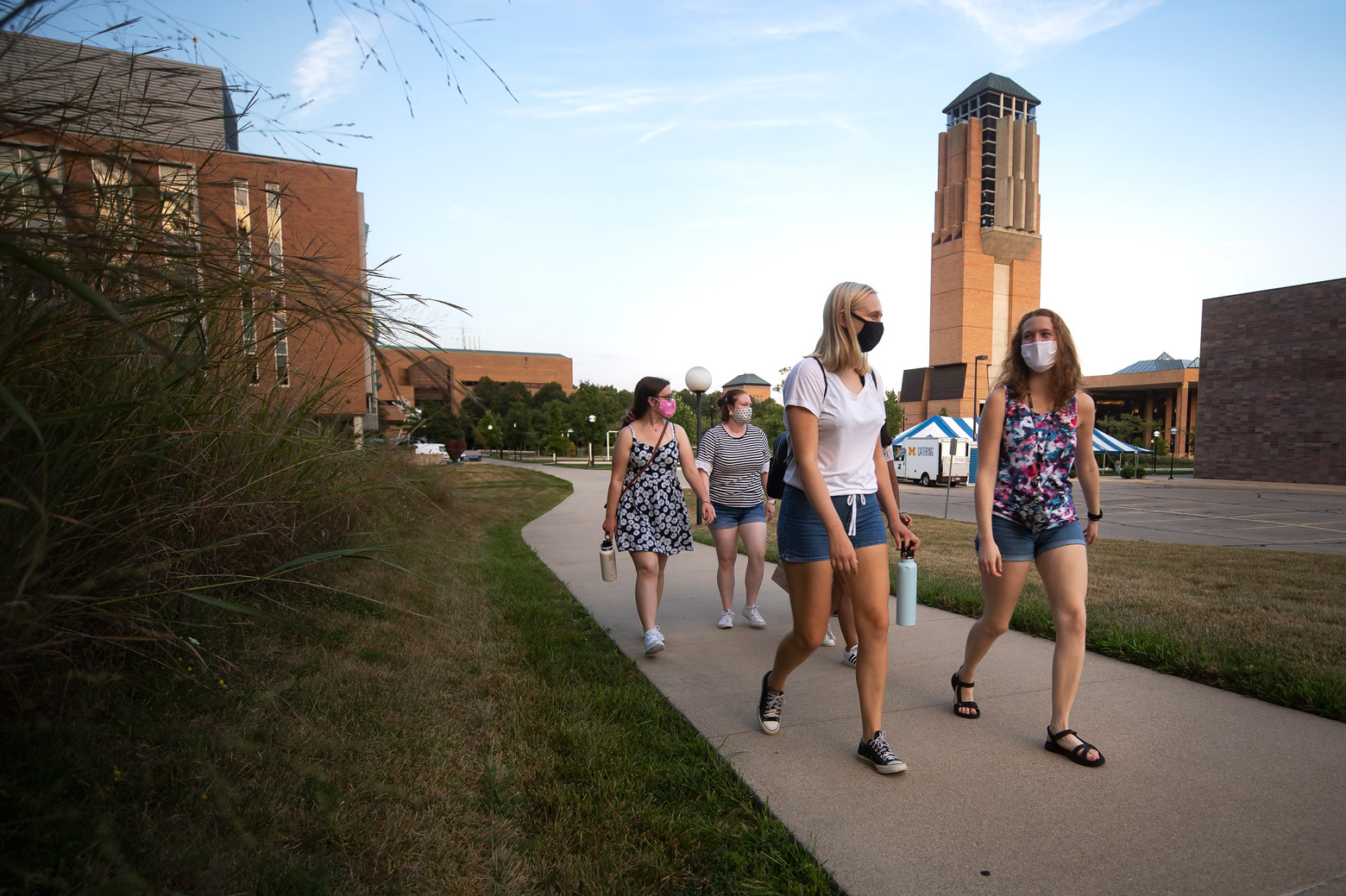 Four women walking in the Grove on campus