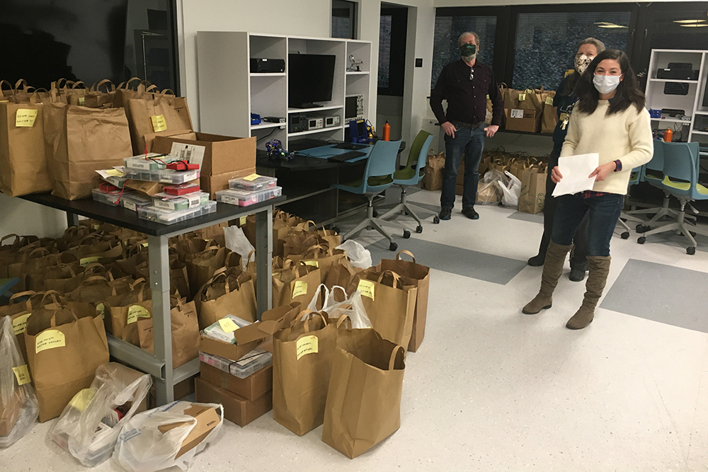 Silvia, Rob, and Paula organize bags of lab kits ready for distribution