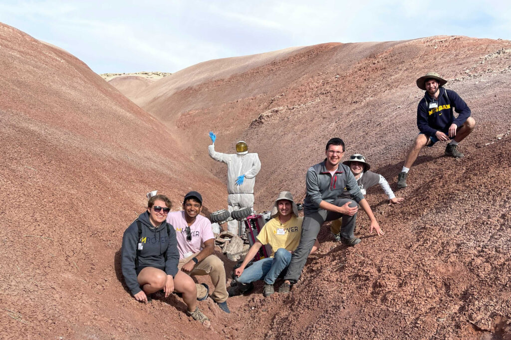 members of MRover and the rover in the desert canyon of Utah
