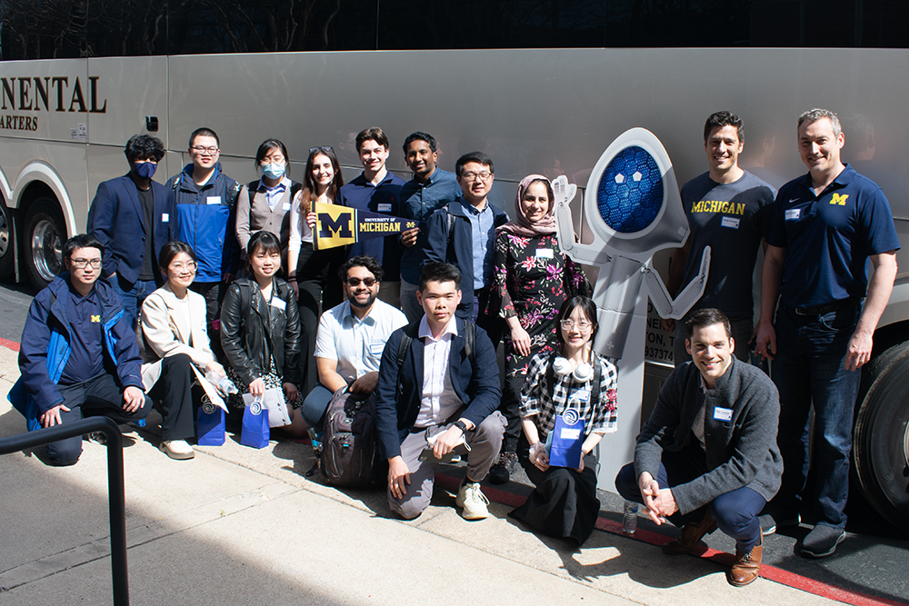 group photo with Ambiq engineers and Ambiq cardboard logo cutout