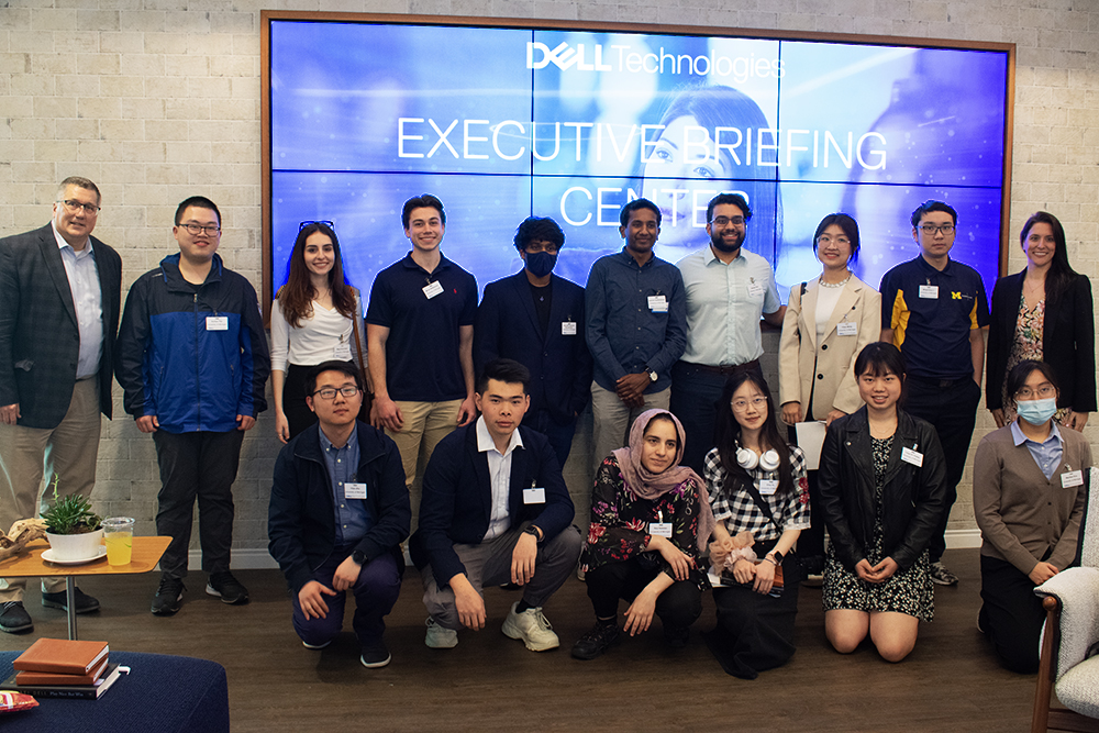 group photo in front of large Dell TV screen showing the name "Dell Technologies Executive Briefing Center"