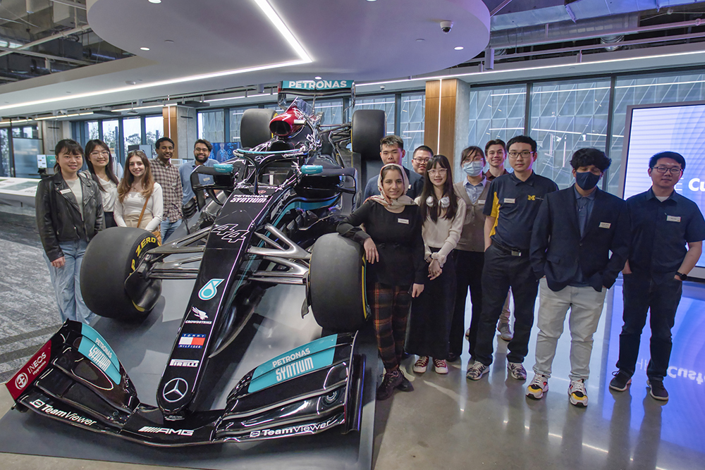 The group stands around the Mercedes-AMG Petronas Formula One Team car
