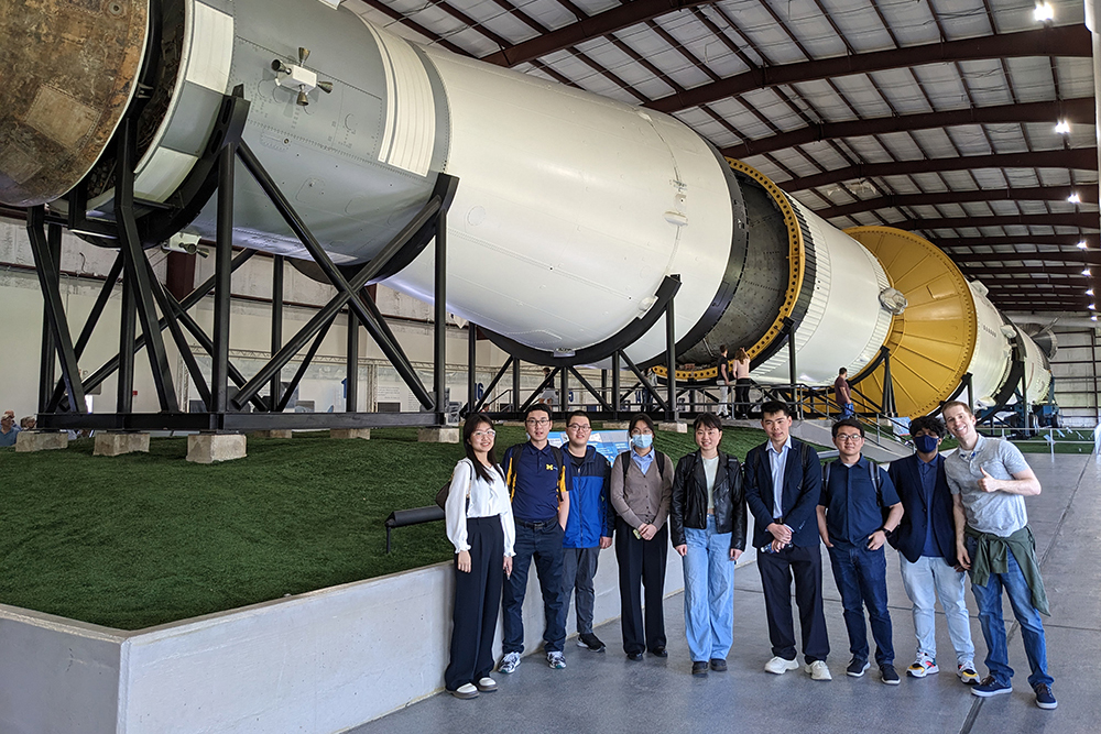 group of students in front of one of the rockets at the Space Center Houston exhibit.