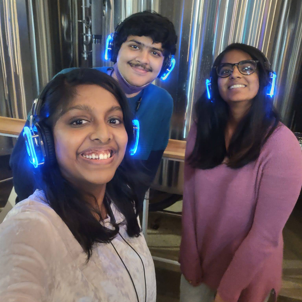 Three students with blue neon headphones