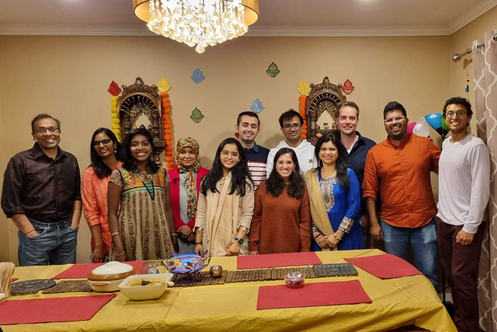 Group of students in Indian dress in front of dinner table dressed for Diwali