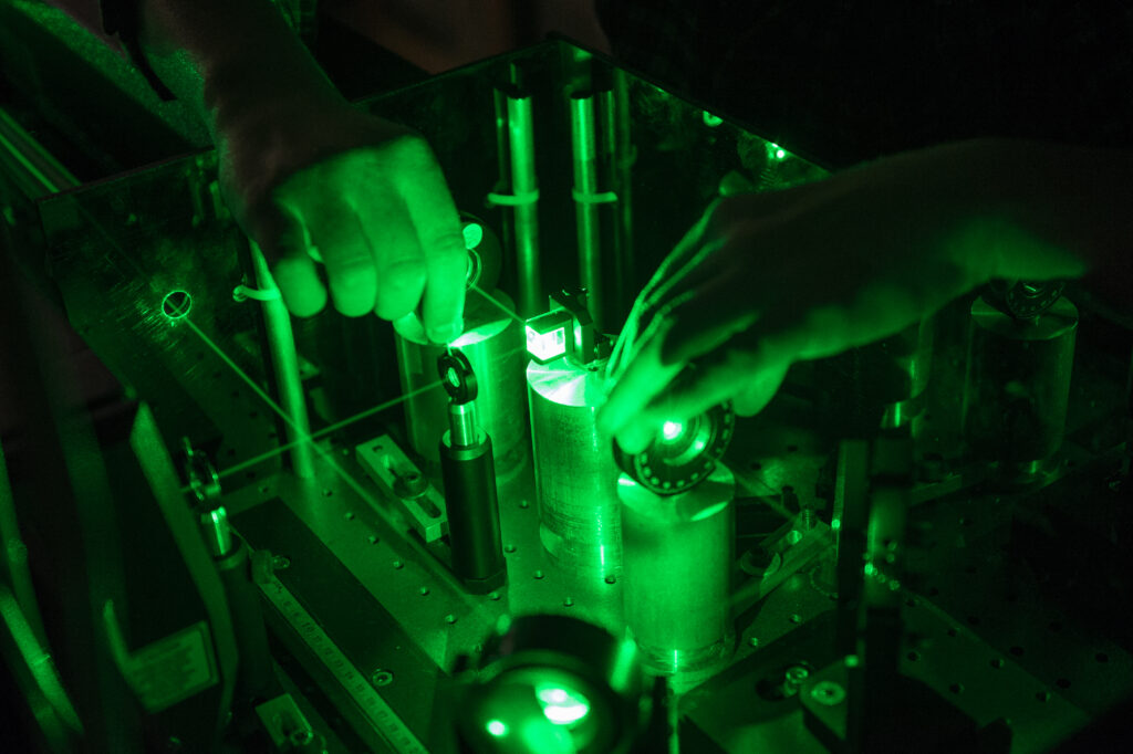 Student adjusts a laser in Duncan Steel's lab