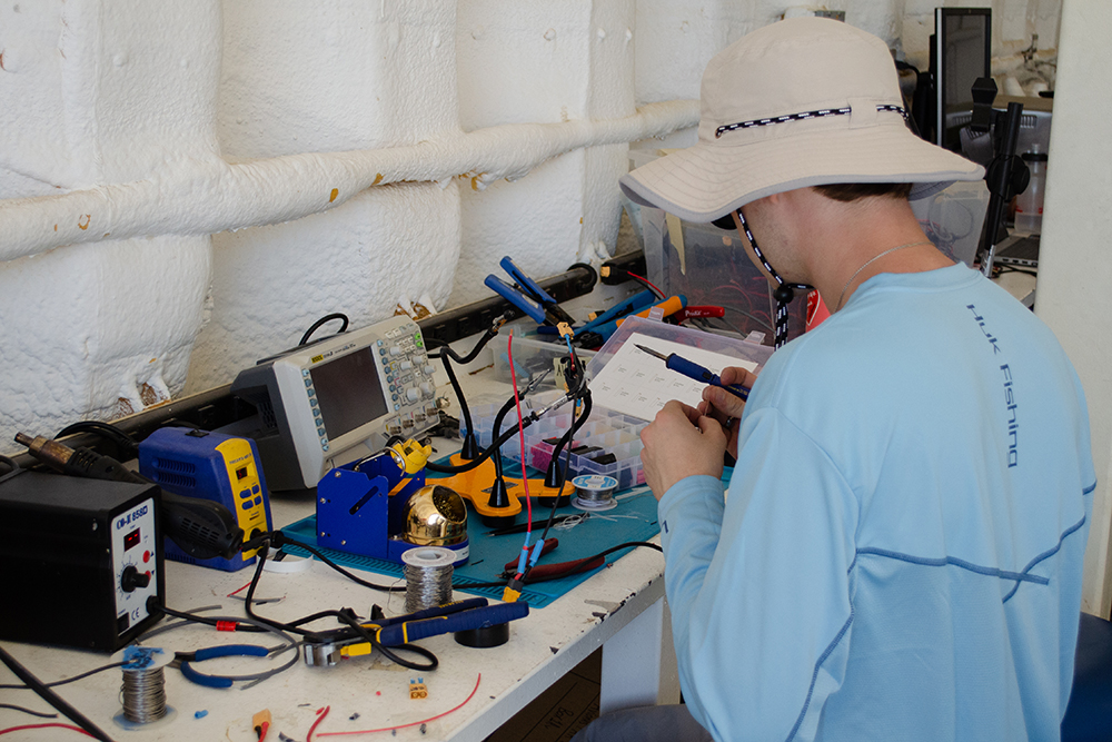 MASA team member at a work bench soldering equipment