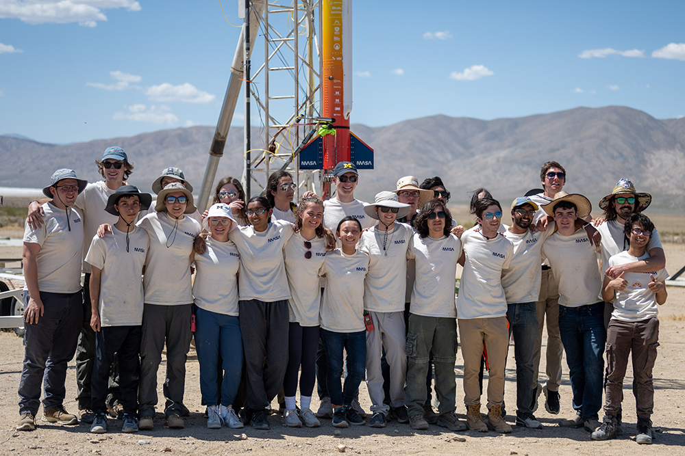 Group photo of the team in front of their rocket