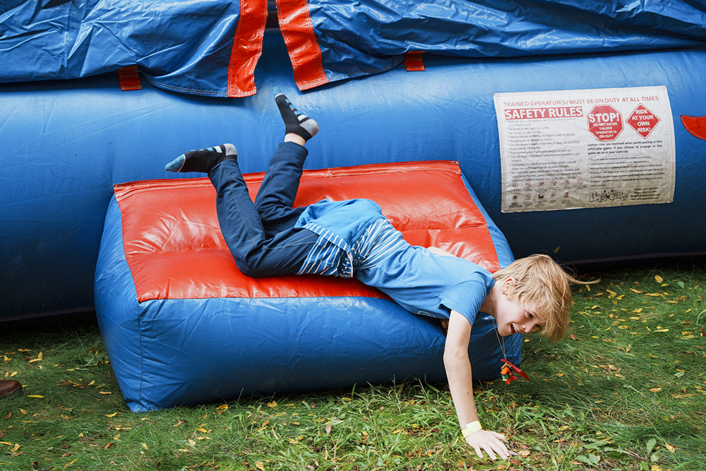 a kid falls out of the bounce house laughing