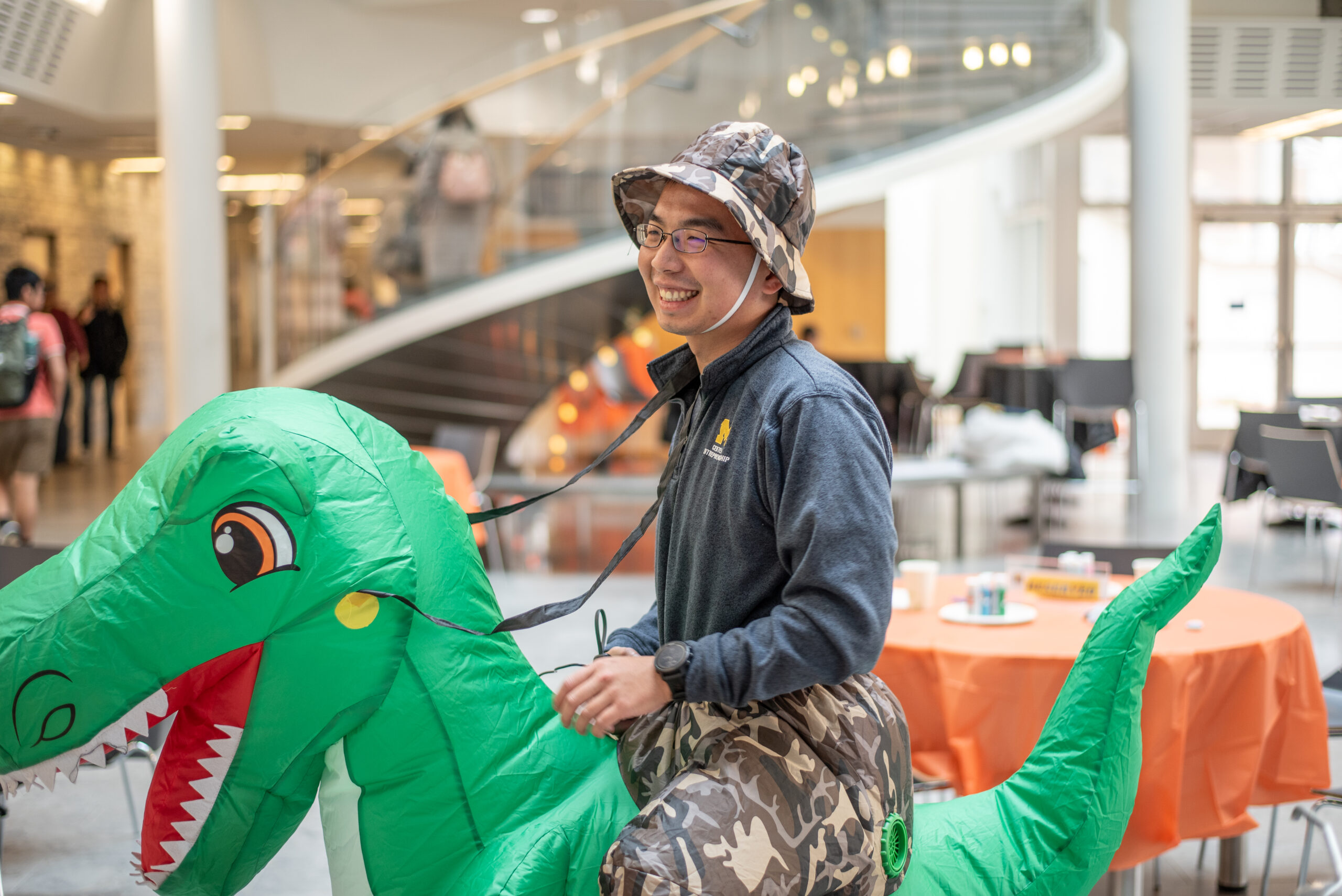 student in an inflatable dinosaur costume