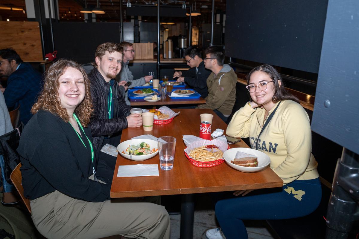 Students and Meta engineers sit around two rectangular tables during lunch at Cafe Epic on Classic Campus.