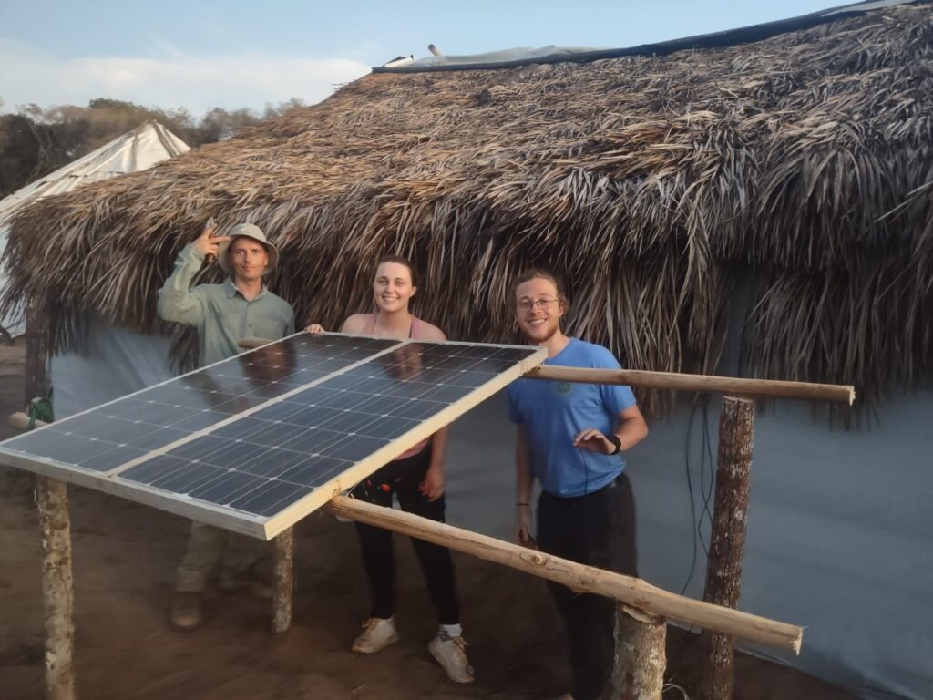 Three individuals installing a solar panel.