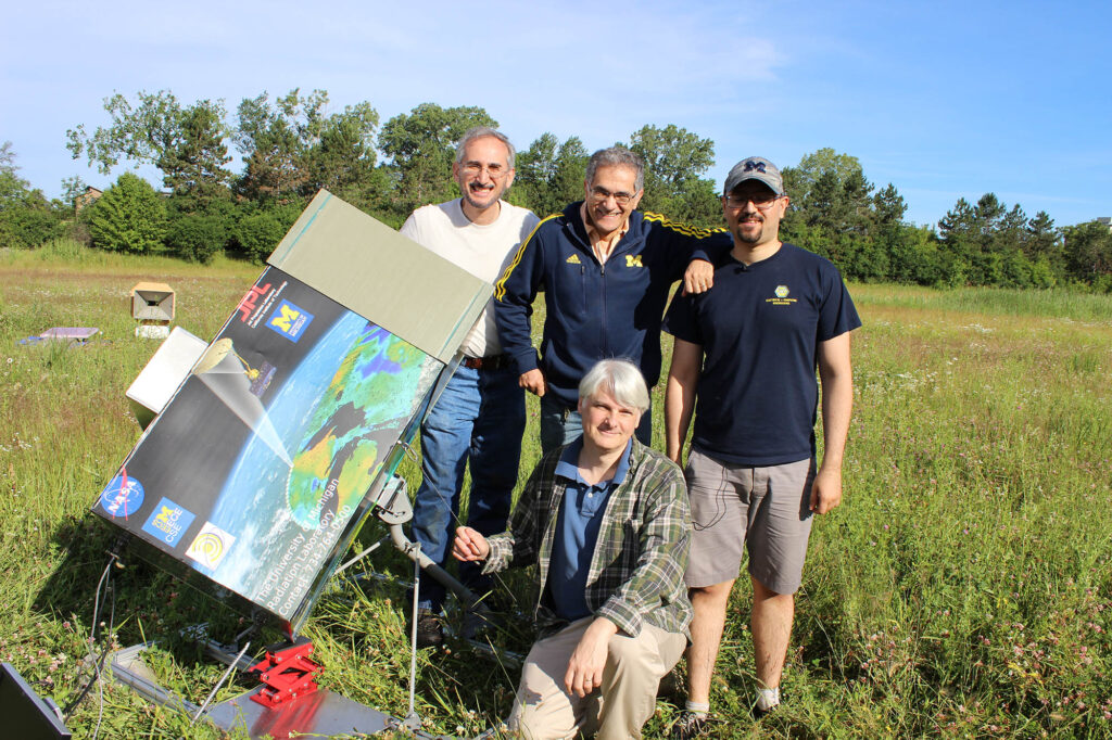 Four researchers in the field with a radar calibration device.