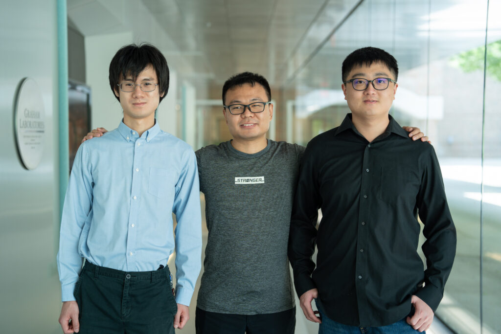 Samuel Yang, Ding Wang, and Danhao Wang standing in a long hallway outside the Lurie Nanofabrication Facility.