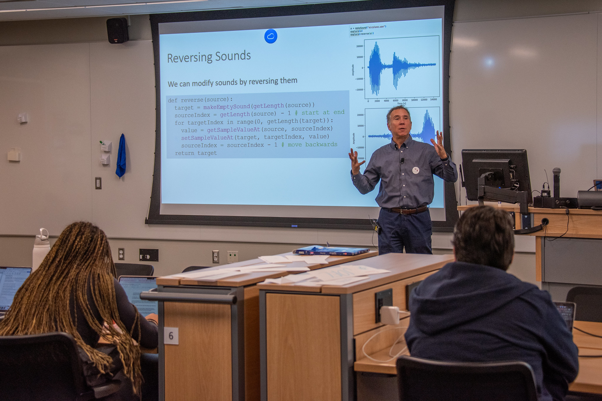 Mark Guzdial lectures in front of a class next to a projection screen