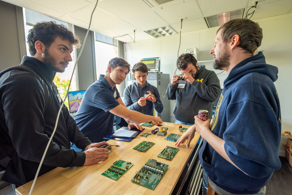 Four ECE students look at chips made at Movellus and talk to employees.