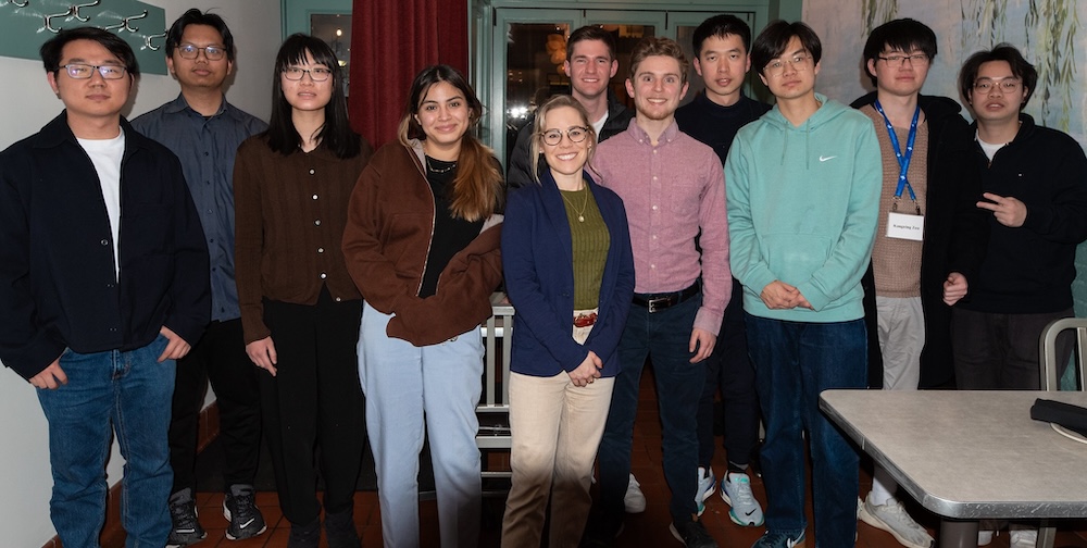 A group of people stands in a restaurant.