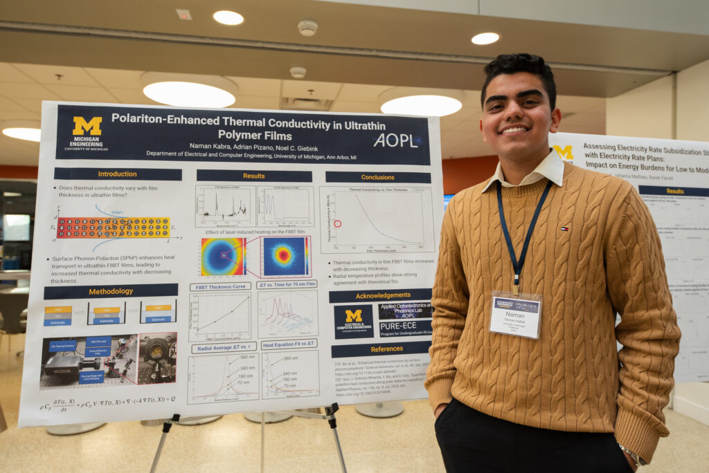 Naman Kabra stands next to his research poster.